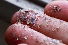 A close-up of a hand holding tiny pieces of plastic.