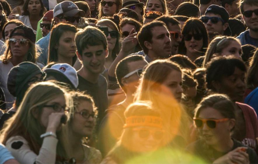 large crowd on a bright day with a lens flare in the foreground